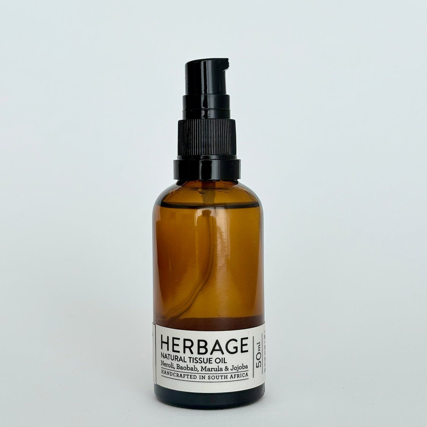 Brown glass bottle with black spray nozzle on a light gray background