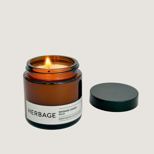 Amber candle in a glass jar with a visible label on a light gray background